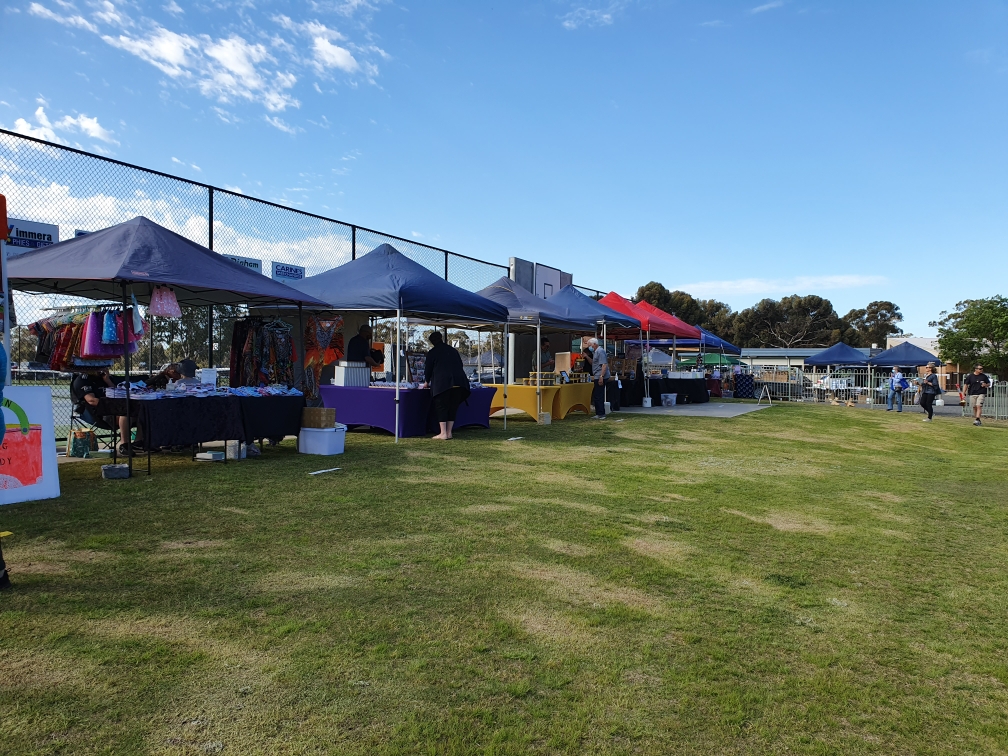 Market stalls set up under a clear blue sky at the Haven Reserve